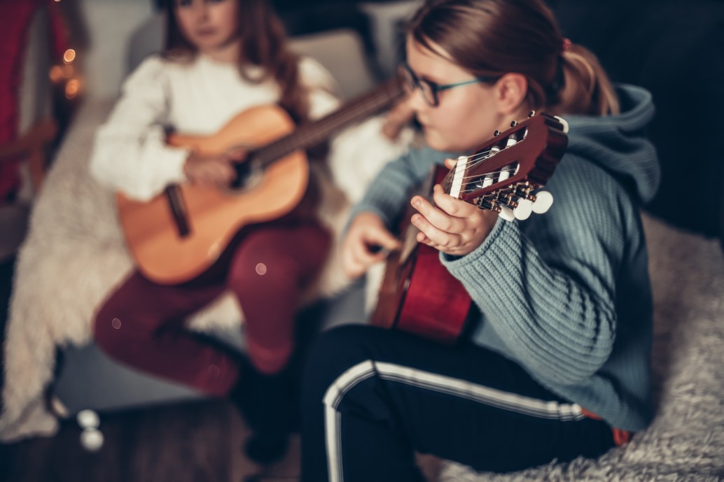 two-teenage-girls-rehearse-the-guitar-music-lesson-at-home-preparing-for-a-concert-playing-the-guitar_t20_1dG33W